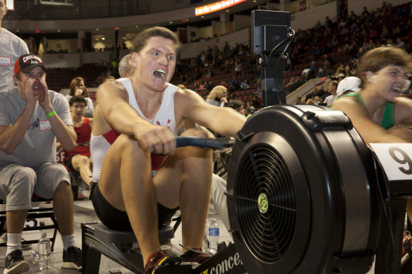 Image of young man rowing with high intensity.